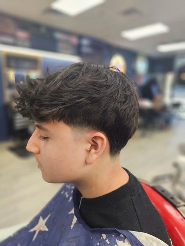 Men’s haircut with textured top and faded sides at Daniel’s Barber Shop