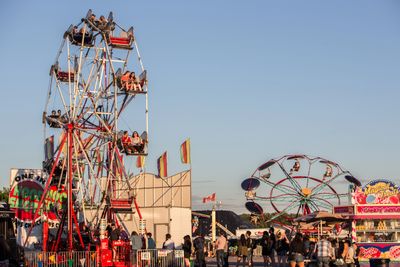 People riding ferris wheel at a fair.