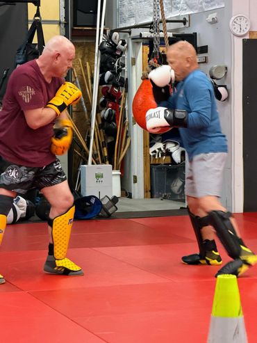 Two men sparring in a boxing gym.