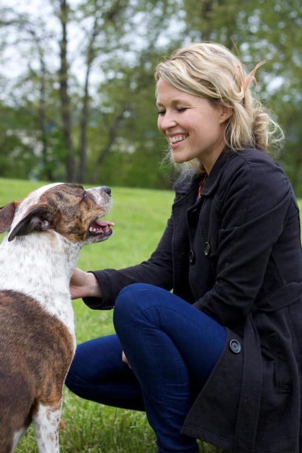 Owner and Dietitian, Casey Wallner, happily interacting with her dog outdoors.