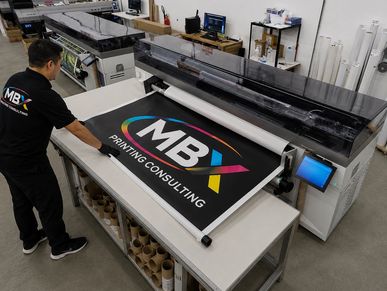 Man handling large printed banner with MBX Printing Consulting.