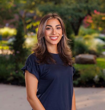 Smiling young woman outdoors in a garden.
