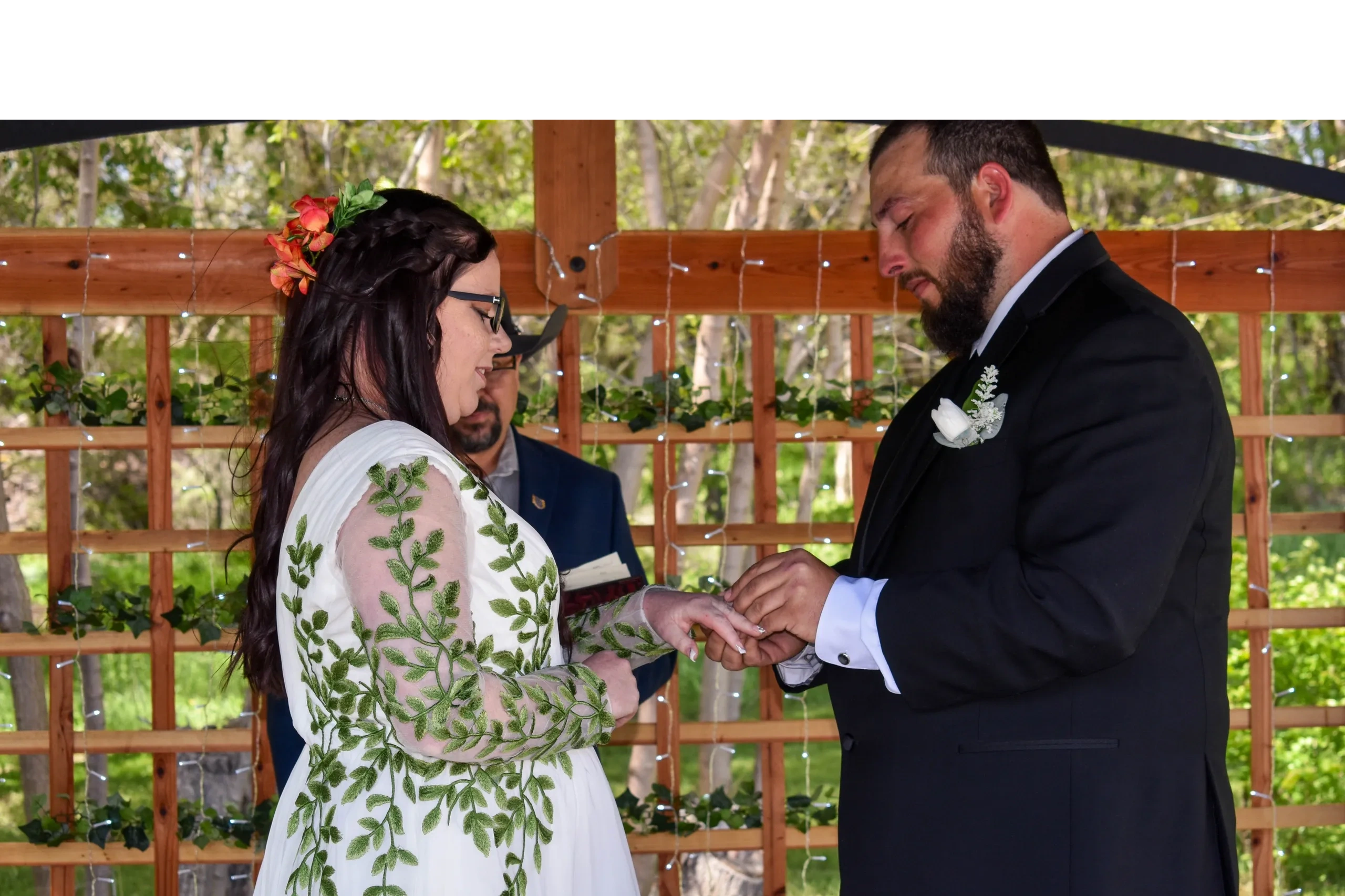 Groom placing the wedding ring on his bride's finger as she says I do.