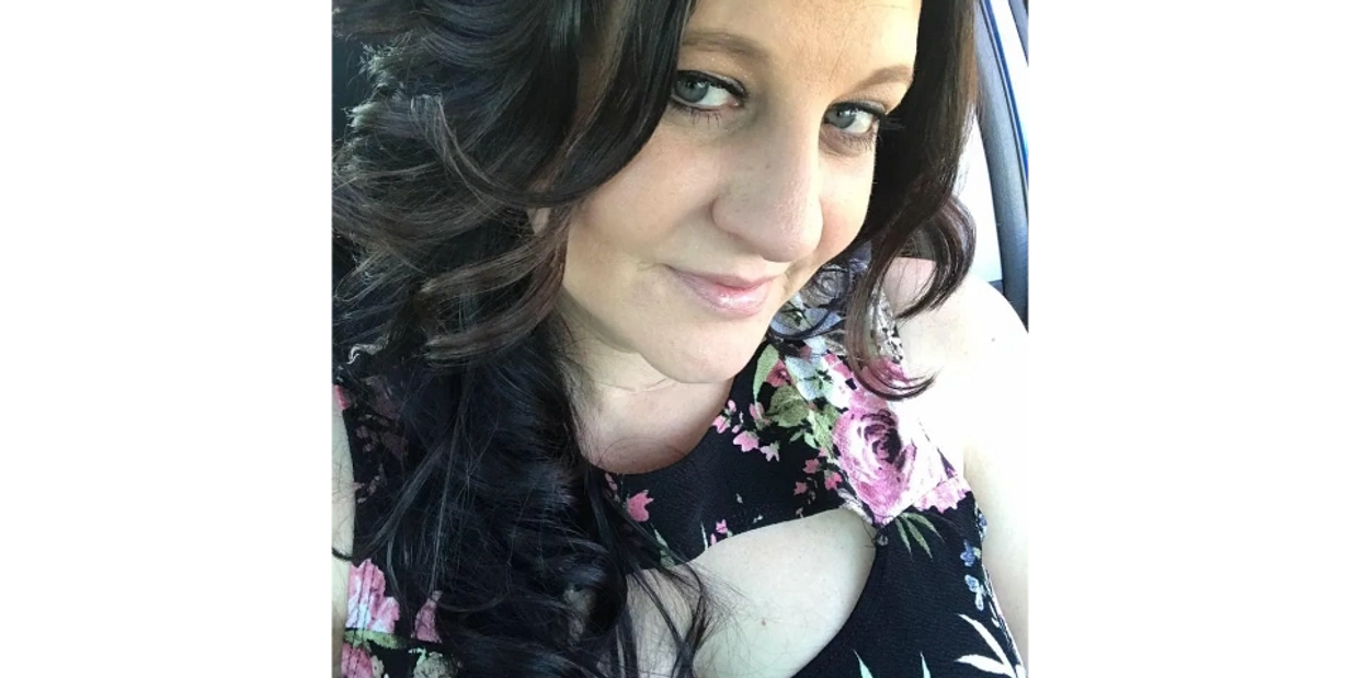 Photographer Kristy Urain in a black and pink floral dress on the way to a photo session.