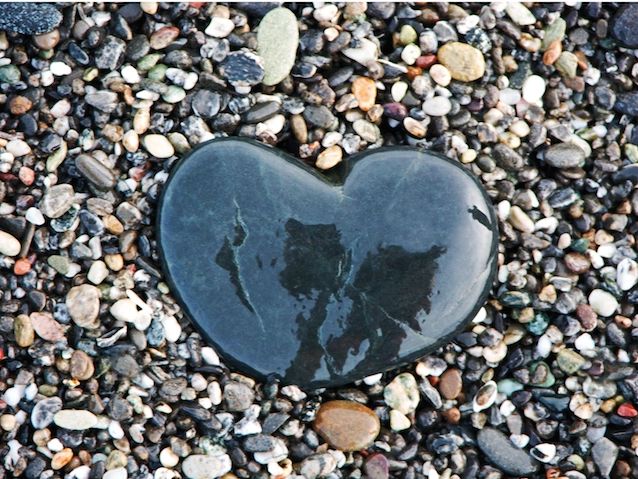 Heart-shaped stone on pebbles symbolizing love and connection.