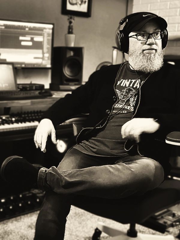 Man with headphones sitting in a music studio.