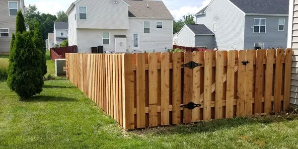 Newly installed wooden fence enclosing a backyard in a suburban neighborhood.