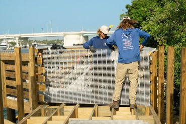 America Strong Construction crew installing dock grating and waterfront fencing in South Florida