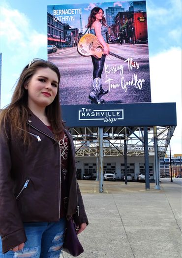 Woman standing near a billboard in Nashville.