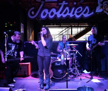 Band performing on stage at a venue named "Jootsie".