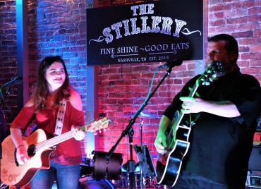 Two musicians playing guitars at The Stillery in Nashville.