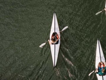 Aerial view of people kayaking on calm water.