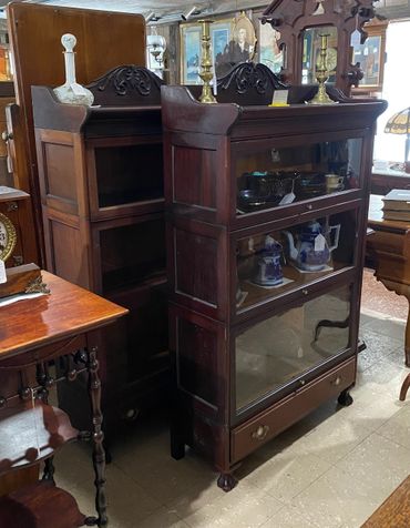 Matched pair of mahogany stacked bookcases, drawered bases, carved galleries
