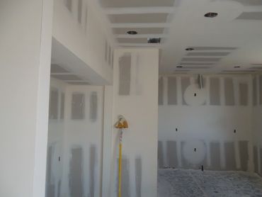 Interior room under construction with drywall installation in progress.