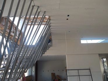 Interior of a building under construction with exposed metal framing and drywall.