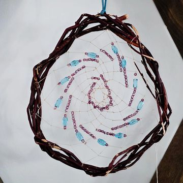 Handmade dreamcatcher with beads and woven wooden frame.