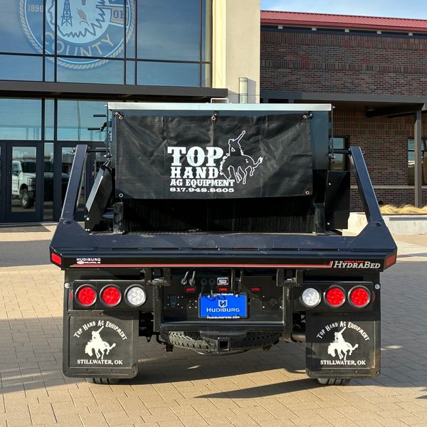 Rear view of a black HydraBed truck with Top Hand Ag Equipment branding.