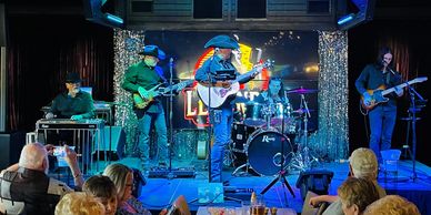 Country band performing live on stage in front of an audience.