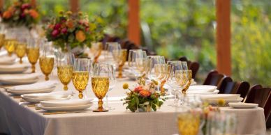 Elegant table setting with amber glassware and floral centerpieces for a formal event.