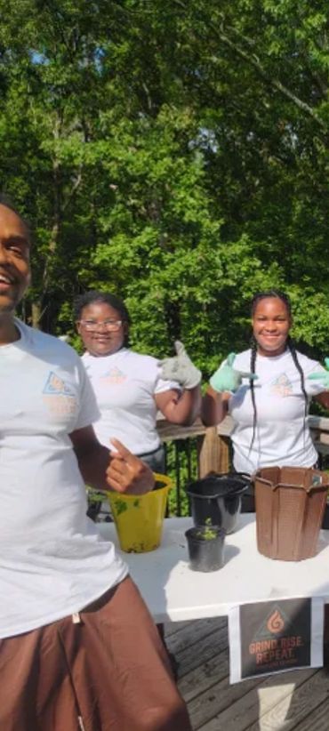 ASHE CORE LEBRON WITH A GROUP OF STUDENTS PLANTING FUTURE TREES IN POTS. ASHE CORE YOUTH EMPOWERMENT