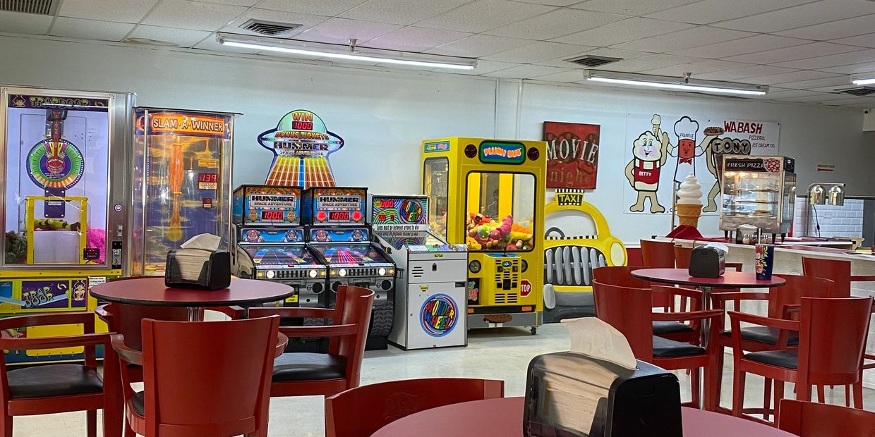 Inside restaurant with tables and arcade machines