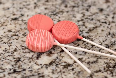 Three cake pops on the counter.