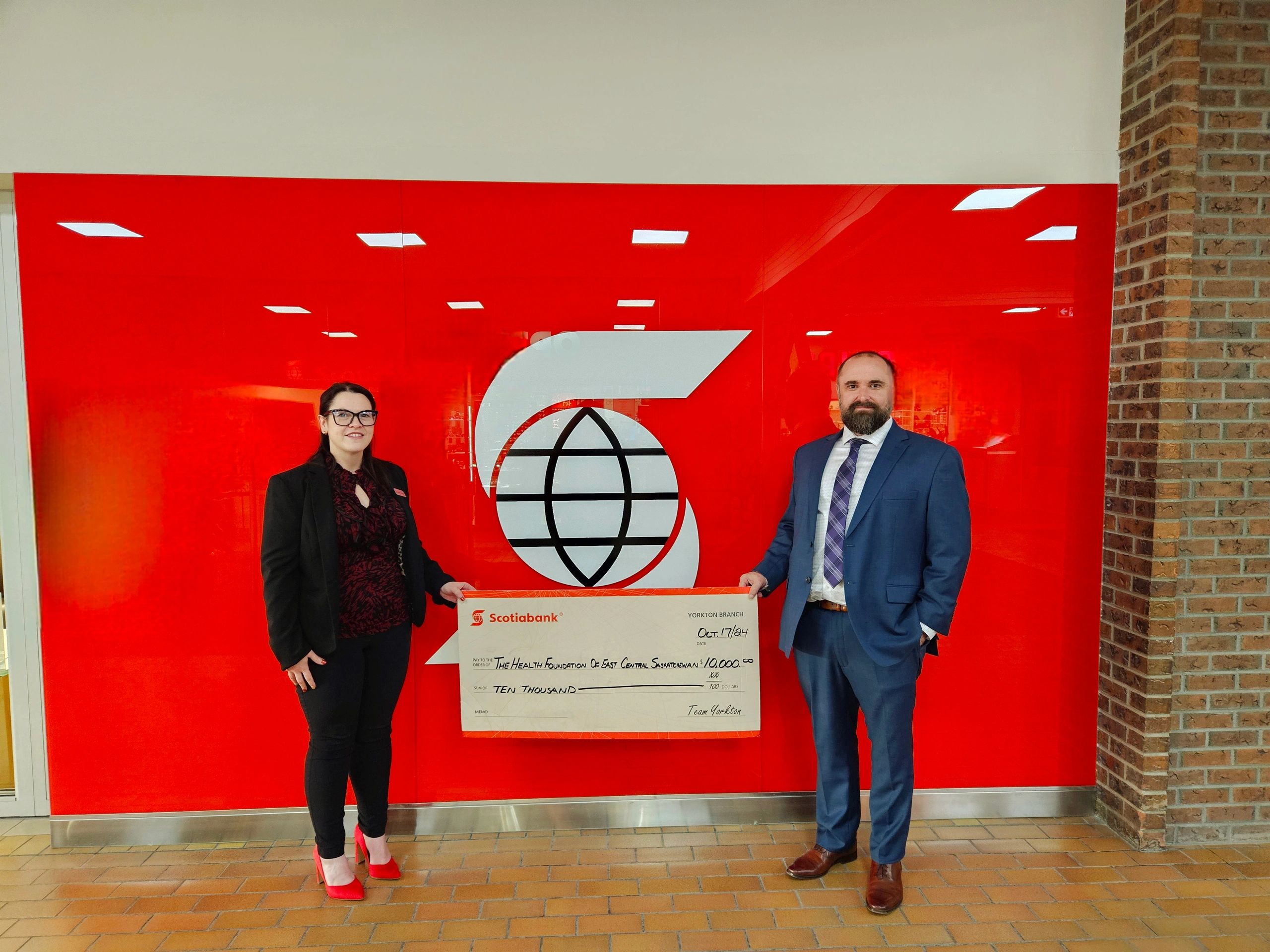 Dale Brock accepts a cheque from Scotiabank Yorkton for 10,000 dollars.