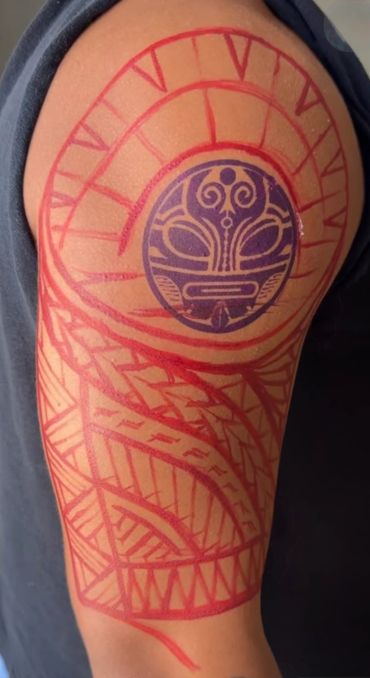 Tribal tattoo outline with a detailed circular design on upper arm.