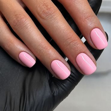 Hand with pink polished nails on a black glove.
