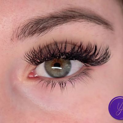Close-up of an eye with long eyelashes and a well-defined eyebrow.