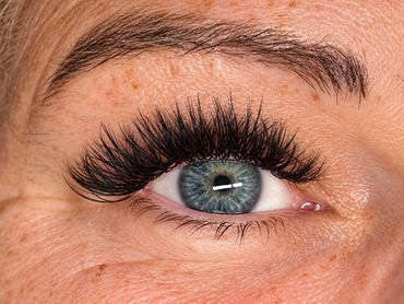 Close-up of an eye with long lashes and freckles.