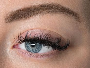 Close-up of a blue eye with long eyelashes.