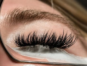 Close-up of eyelash extensions with a mirror reflection.