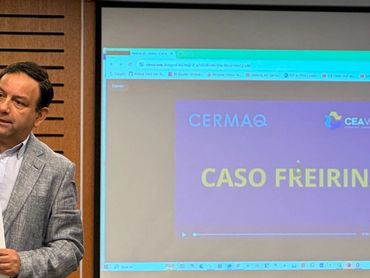 Man giving a presentation titled 'CASO FREIRINA' in a conference room.