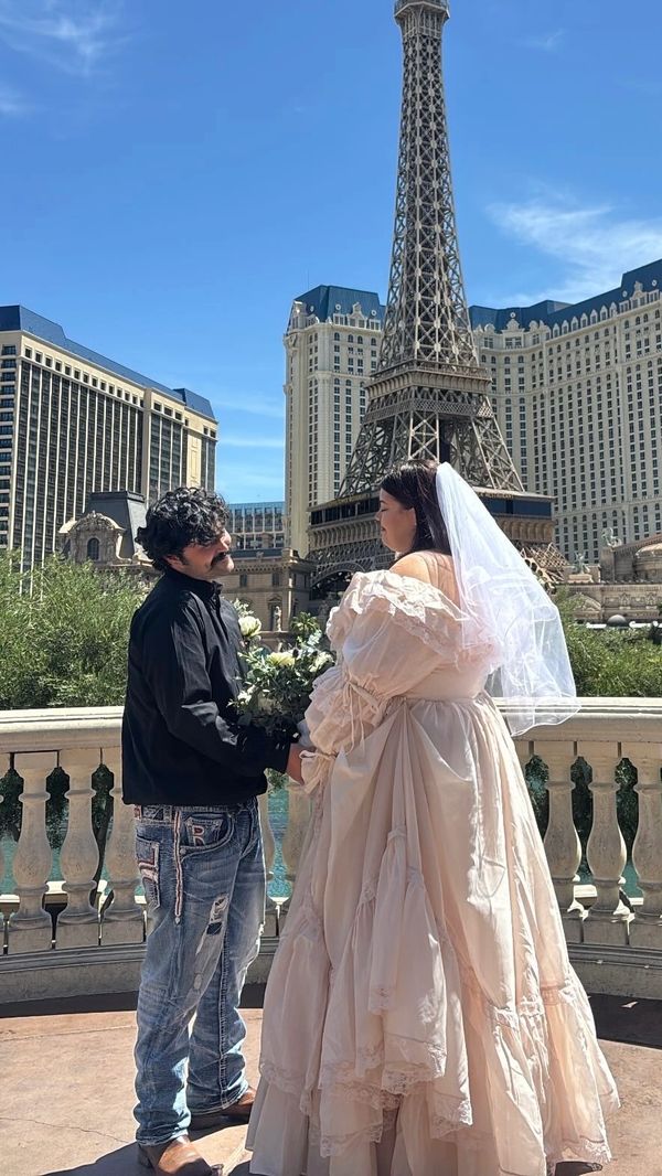 Couple in wedding attire near the Eiffel Tower replica in Las Vegas.