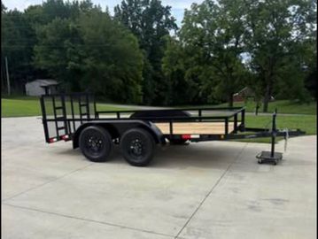 Black utility trailer parked on concrete.