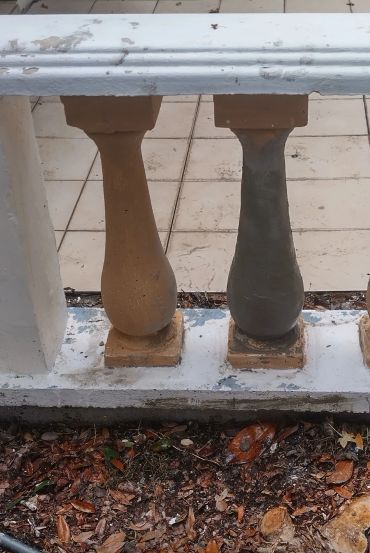 Two balusters, one newly painted gray.