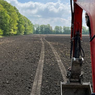 Excavator making tracks in a freshly graded yard