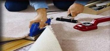 A man fixing the mat of a house with machines