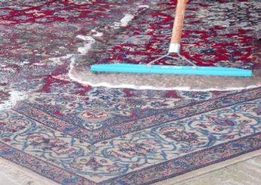 A mop cleaning a designer mat on the floor