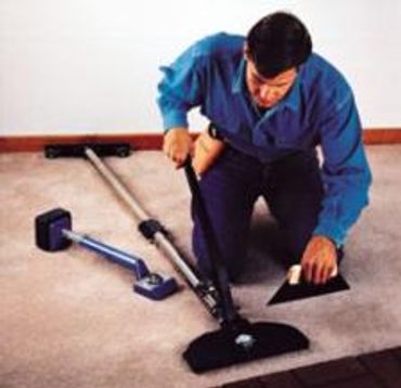 Close up shot of a man fixing mat of a room with machine