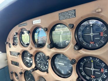 Close-up of an airplane cockpit instrument panel with various flight gauges.
