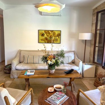 Cozy living room with natural wood furniture and floral accents.