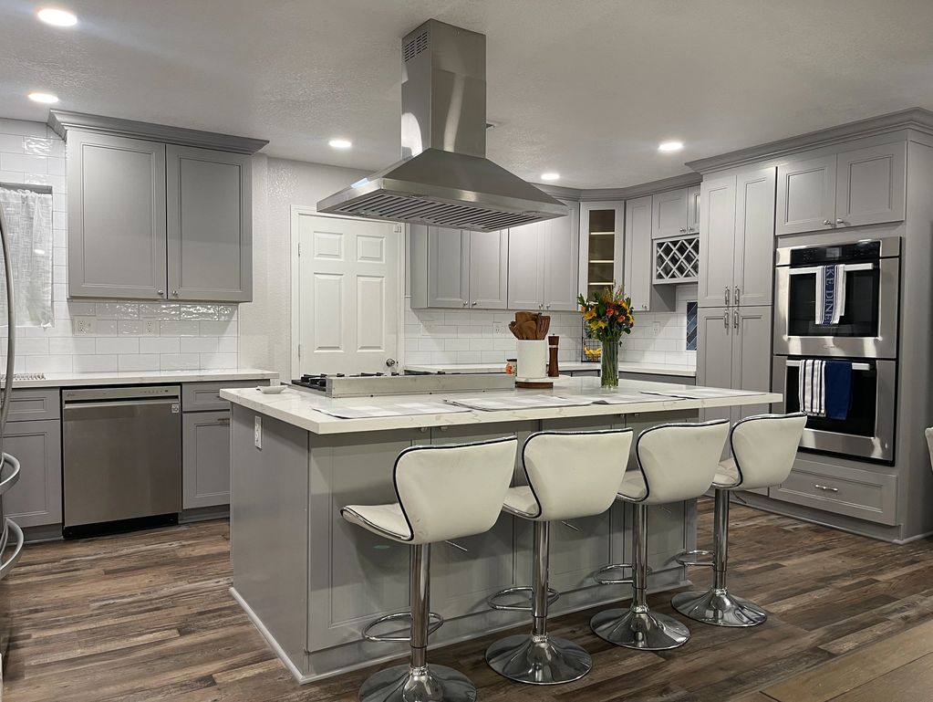 Luxury kitchen remodel with gray cabinets, quartz countertops, and a farmhouse sink.