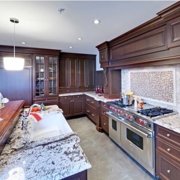Luxury kitchen remodel with gray cabinets, quartz countertops, and a farmhouse sink.