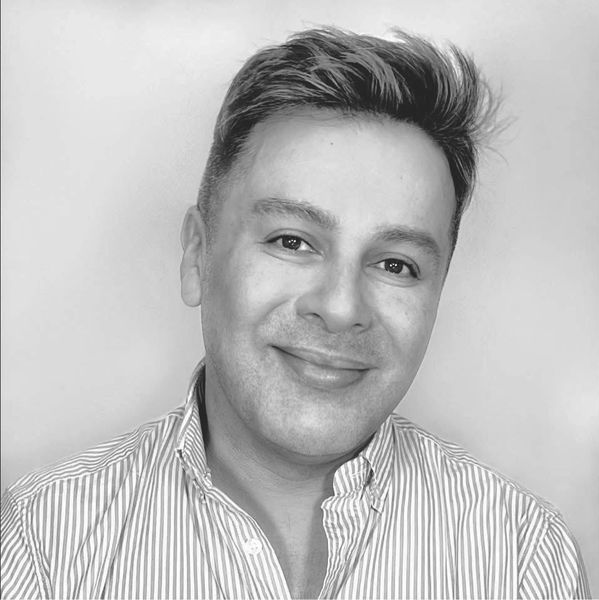 Smiling man in a striped shirt with neatly styled hair.