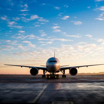 Airplane on runway at sunset.
