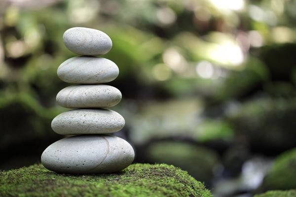This image shows a stack of five smooth, rounded stones carefully balanced on top of one another.