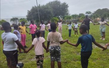 kids with instructor in a circle holding hands