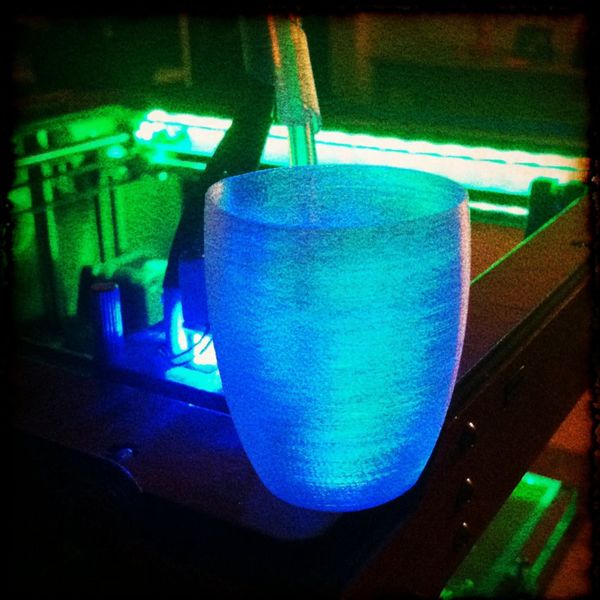 Translucent 3D printed cup, backlit by blue and green LEDS.